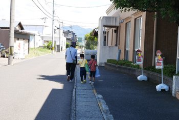 「いってきます」　職員の手にひかれて